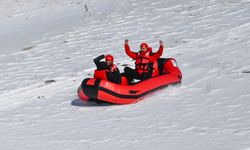 Karla kaplı dağdan donmuş gölete botla kaydılar