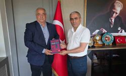 Başkan Öztürk'ten Kaymakam Güney'e 'Helvacı Kilimi' kitabı takdimi