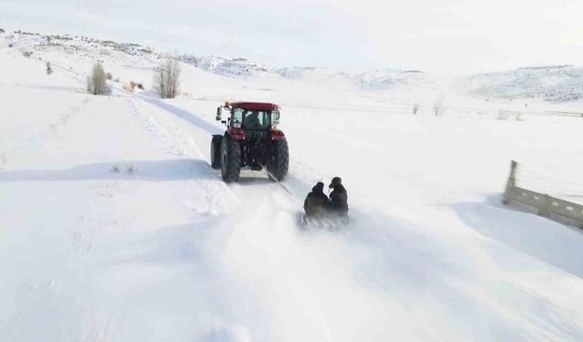 Kar yağışını fırsata çevirdiler, traktörün arkasında kayarak eğlendiler
