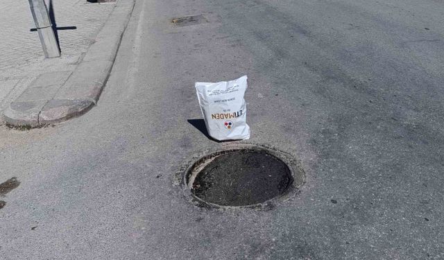 Çöken rögar kapağını gören vatandaş poşetle önlem aldı